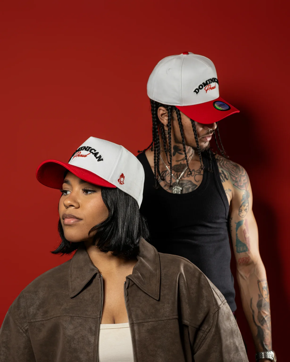Dos modelos luciendo gorras Dominican Proud